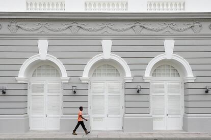 Un hombre camina ante la fachada del teatro Victoria en Singapur, que abrió sus puertas tras cuatro años de reformas. 17 de julio de 2014.