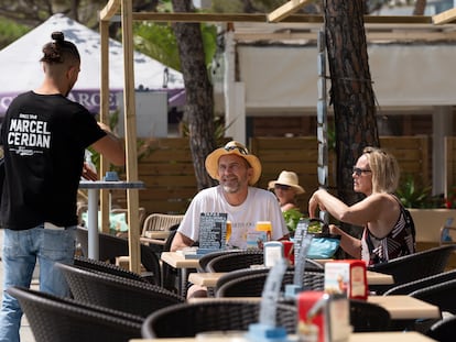 Un camarero atiende a clientes en Platja d'Aro, en Girona, en junio de 2022.