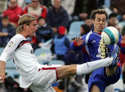 Poulsen y Nacho luchan por el balón.