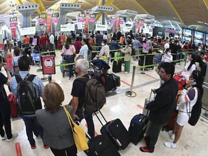 Decenas de personas hacen cola en el Aeropuerto de Barajas de Madrid.