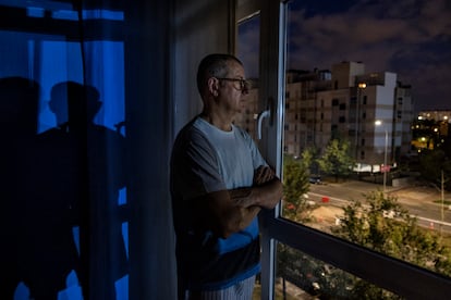 César Martínez mira por la ventana de su casa de madrugada. 