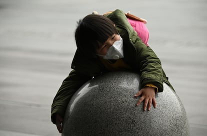 Un niño con mascarilla juega en la estación de tren de la ciudad china de Changsha.