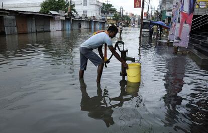 Un hombre indio bombea agua en una calle inundada después de una tormenta del ciclón Mora en Agartala, la capital del estado noreste de Tripura.