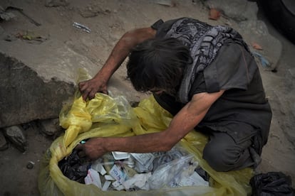 Un drogadicto busca jeringuillas y otro material entre los desechos sanitarios de una bolsa de basura de un centro médico, el 20 de septiembre. Los talibanes han recuperado la tradición de llevar a cabo redadas de dorgadictos y trasladarlos, a veces a golpes, a un centro de Kabul para su ingreso.