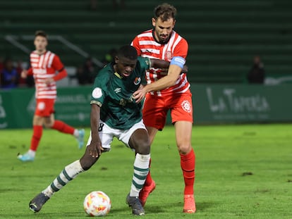 Cristian Stuani, del Girona, en una acción con el defensa del Cacereño, Ousmane Traoré, durante el partido de la segunda ronda de la Copa del Rey, en el estadio Príncipe Felipe este jueves.