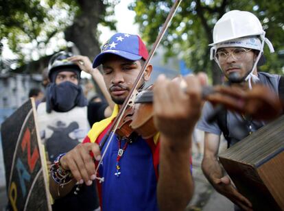 A criatividade tem sido uma arma dos manifestantes venezuelanos. Na imagem, Wuilly Arteaga toca violino durante confronto contra forças de segurança do Governo