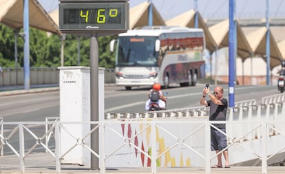 Un hombre fotografía un termómetro en una calle de Sevilla, este viernes.