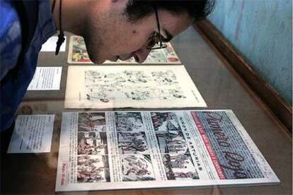 Un visitante del Salón del Cómic contempla una historieta de la exposición <i>La guerra de papel.</i>