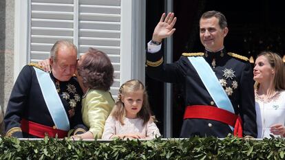 La reina Sofía besa al rey Juan Carlos en el balcón del palacio Real de Madrid, mientras el rey Felipe saluda al público congregado en la plaza de Oriente, junto a la princesa Leonor y la reina Letizia, en la proclamación de Felipe VI, el 19 de junio de 2014.