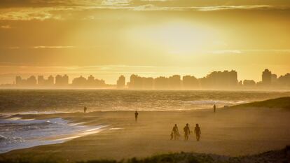 Surfistas al atardecer en una de las playas de Punta del Este. 