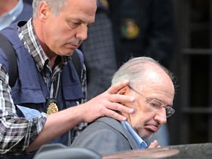 Rodrigo Rato is guided into a patrol car following his arrest on Thursday.