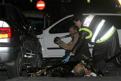 Policías de Homicidios examinan el cadáver de Esteban Gallardo junto a su vehículo.