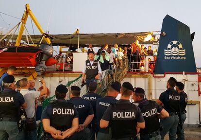 El 'Sea-Watch 3', además, llevaba a bordo a su llegada a Lampedusa a una delegación de parlamentarios italianos de izquierda, que aplaudieron la decisión de Rackete. En la imagen, migrantes desembarcan del barco.