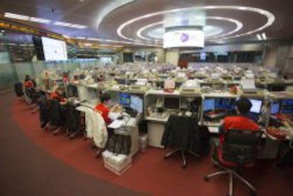 Corredores de bolsa observan las transacciones realizadas en la bolsa de Hong Kong (China).  