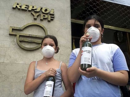 Activistas muestran botellas de agua contaminada en la sede de Repsol en Buenos Aires.