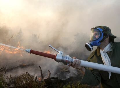 Un voluntario ayuda a extinguir un incendio al norte de la capital de Grecia. La extensión de bosques quemados desde primeros de julio es de unas 15.000 hectáreas