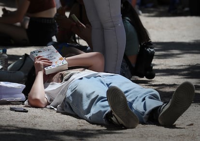 Un lector tendido en el Paseo de Coches en la Feria del Libro de Madrid este sábado. 