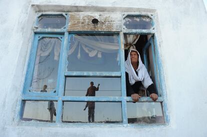 La viuda afgana Bibikoh se asoma a la ventana de su casa, que se levanta en uno de los puntos más altos de una colina situada al este de Kabul, conocida como Zanadab.