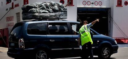 Una trabajadora da indicaciones a uno de los primeros veh&iacute;culos que han embarcado en el Puerto de Algeciras.