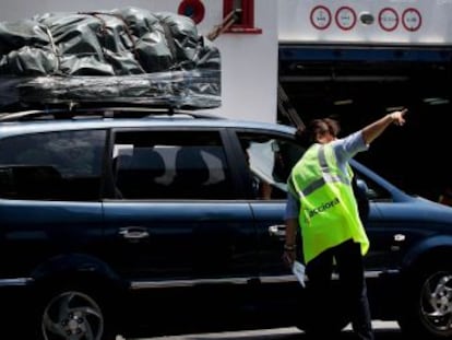 Una trabajadora da indicaciones a uno de los primeros veh&iacute;culos que han embarcado en el Puerto de Algeciras.