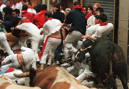 Un toro empitona a un corredor en el séptimo encierro, en 2000.