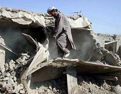 Un afgano limpia los escombros de su casa, muy dañada por los bombardeos de EE UU ayer en Kabul.