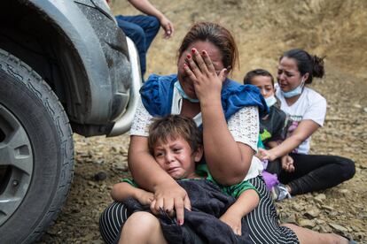 Una migrante llora junto a su hijo luego que la Policía disolviera la caravana de miles de personas que bloqueba la carretera de Vado Hondo, Chiquimula.