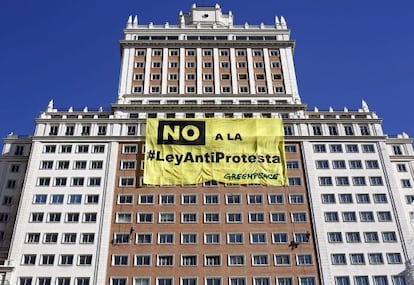 Greenpeace activists unfurl a large placard from the España building in Madrid on Saturday.