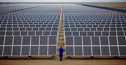 Un trabajador supervisa una instalación solar en Dunhuang (China).