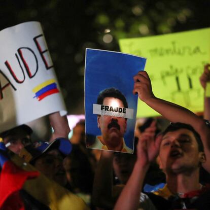 A man holds a poster beside other Venezuelans living in Mexico and members of Comando ConVzla during a protest against the election results that awarded Venezuelan President Nicolas Maduro a third term, in front of the Angel of Independence monument in Mexico City, Mexico July 30, 2024. The sign reads "Venezuela Fraud". REUTERS/Henry Romero