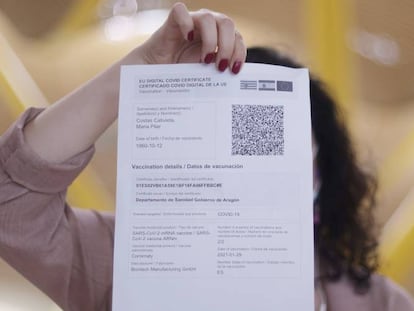 Una mujer muestra una copia impresa de un certificado covid.