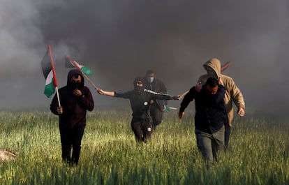 Cinco palestinos corren mientras se enfrentan a las fuerzas israelíes, cerca de la frontera, este miércoles. 