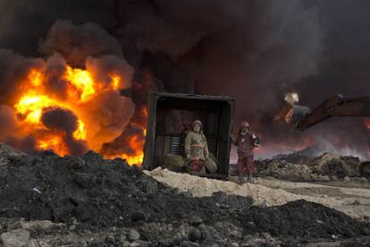 Bomberos trabajan para apaciguar un fuego provocado por militantes islámicos, en Qayara, al sur de Mosul (Irak).