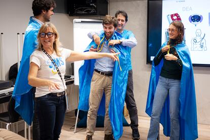 Los organizadores del taller de reanimación cardiopulmonar colocan capas de superhéroes a algunos de los participantes en la sesión.