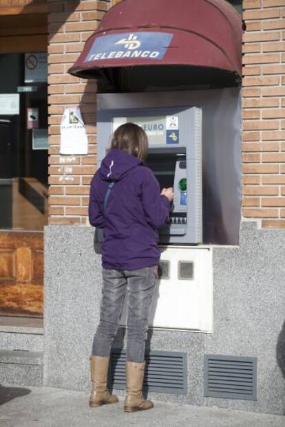 Una usuaria de un cajero autom&aacute;tico en Madrid.