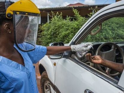 Una treballadora sanitària desinfecta les mans d'un visitant del centre mèdic de Kamsar, a Guinea, el 7 de setembre passat.