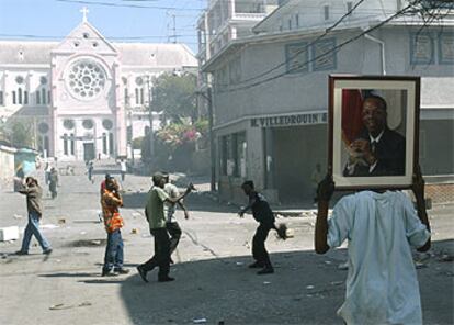 Varias personas recorren las calles de Puerto Príncipe en medio del caos.