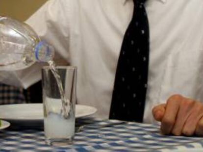Un hombre llena un vaso con una bebida. EFE/Archivo