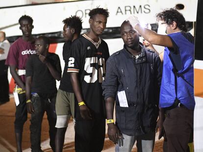 Después de 20 días de bloqueo, los 83 migrantes que aún seguían a bordo del barco español pisaron tierra firme en la isla italiana de Lampedusa. Horas antes, el fiscal de Agrigento (Sicilia), Luigi Patronaggio, había ordenado, tras realizar una inspección del buque, su incautación y el desembarco inmediato de los náufragos. Minutos antes de que llegase la orden del fiscal italiano, había zarpado de la base naval de Rota (Cádiz) el buque de la Armada española Audaz con la misión de recoger a los 83 migrantes.En la imagen, varios inmigrantes del 'Open Arms' son atendidos tras desembarcar la madrugada del jueves en el puerto de Lampedusa.