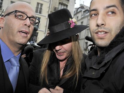John Galliano (en el centro) acude a una comisaría de París en febrero pasado.