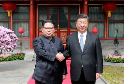 Kim Jong-un y Xi Jinping se saludan durante la visita del primero a Pekín el 27 de marzo de 2018. 
 