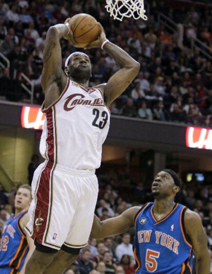 El jugador de los Cleveland Cavaliers LeBron James salta hacia la red ante el defensa de los Knicks Bill Walker.