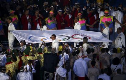 La bandera olímpica entra en es estadio.