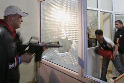 Un militante de Al Fatah rompe con su fusil el cristal de una ventana de las oficinas del Gobierno palestino.