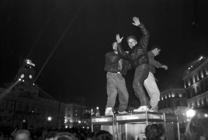 Unos jóvenes celebran la Nochevieja subidos en el techo de una cabina telefónica de la madrileña Puerta del Sol en 1992.