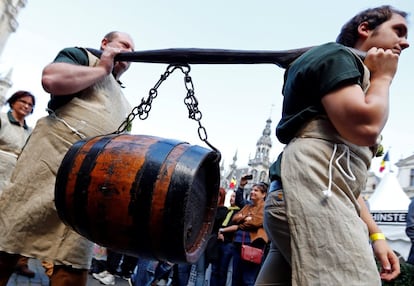 Dos personas portan un barril de cerveza en la Grand Place de Bruselas (Bélgica) antes de una misa en honor a Saint-Arnould, patrón de los cerveceros.