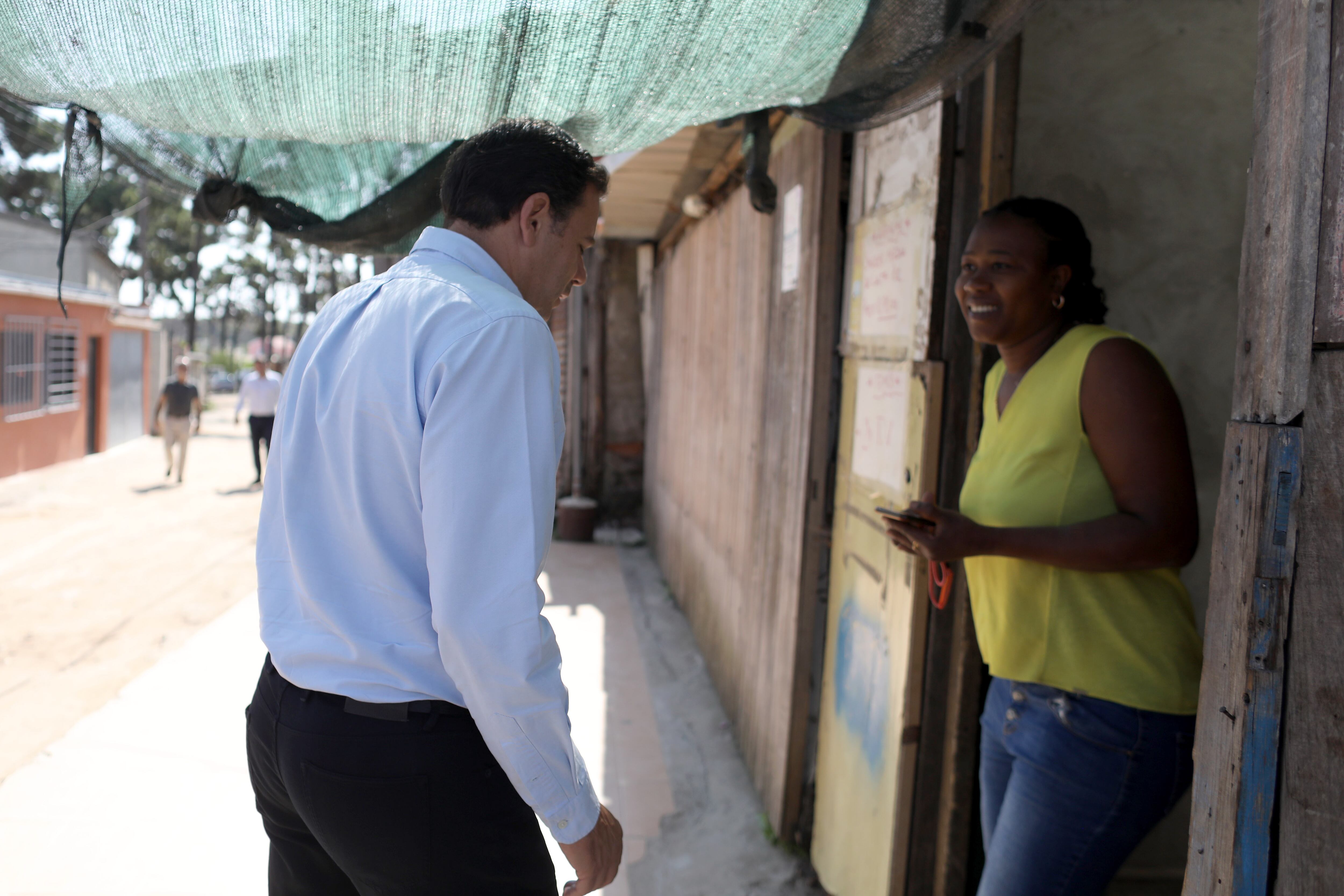 Luís Montenegro, presidente del Partido Social Demócrata de Portugal, conversa con una vecina del barrio de chabolas de Santa Marta do Pinhal, en Seixal, el pasado 22 de junio.