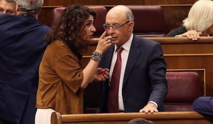 La ministra de Hacienda, María Jesús Montero, conversa con el diputado popular y exministro Cristóbal Montoro, en junio de 2018. 