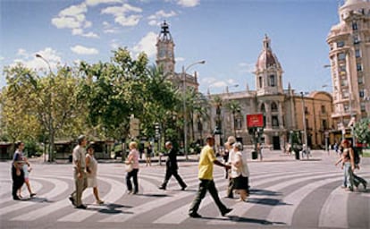 Paseantes por la plaza del Ayuntamiento de Valencia, libre de coches en la jornada de ayer.