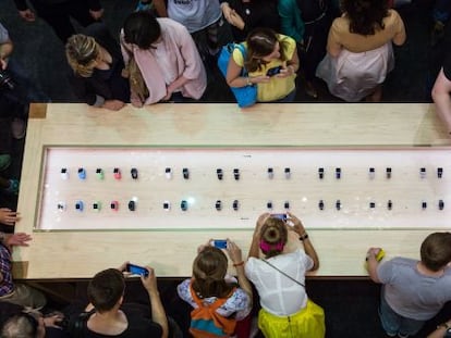 Un grupo de clientes rodea un mostrador de Apple Watch en una tienda de Mosc&uacute;.